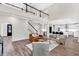 Bright open floor plan featuring living room and kitchen, hardwood floors, and a staircase leading to the second floor at 3987 Tamarack Nw Dr, Kennesaw, GA 30152