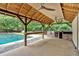 Outdoor bar with a stone counter, bar, and concrete floors featuring exterior view of the pool at 3987 Tamarack Nw Dr, Kennesaw, GA 30152