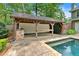 Pool house featuring an outdoor bar with a stone counter, concrete floors, with exterior view of the pool at 3987 Tamarack Nw Dr, Kennesaw, GA 30152