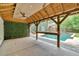 An outdoor poolside bar features a ceiling fan, a wooden bar, and an eye-catching green wall of greenery at 3987 Tamarack Nw Dr, Kennesaw, GA 30152