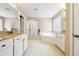 Bright bathroom featuring double sinks, a soaking tub, and a glass-enclosed shower, perfect for relaxation at 1489 Belmont Hills Dr, Suwanee, GA 30024