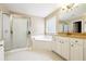 Bathroom featuring double sinks, a soaking tub, and a glass-enclosed shower, perfect for relaxation at 1489 Belmont Hills Dr, Suwanee, GA 30024