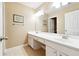 Bathroom with white double sinks, tile flooring, and a large mirror at 1489 Belmont Hills Dr, Suwanee, GA 30024