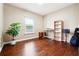 Bedroom with hardwood floors, a window, a plant and a desk with a book shelf in a neutral color scheme at 1489 Belmont Hills Dr, Suwanee, GA 30024