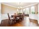 Elegant dining room with hardwood floors, decorative chandelier, and stylish wainscoting at 1489 Belmont Hills Dr, Suwanee, GA 30024