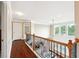 Upstairs hallway featuring hardwood floors and a view of the living area below through an ornate railing at 1489 Belmont Hills Dr, Suwanee, GA 30024
