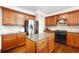 Modern kitchen featuring stainless steel appliances, wood cabinetry, and a granite countertop island at 1489 Belmont Hills Dr, Suwanee, GA 30024