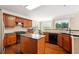 Kitchen featuring wood cabinets, black appliances, granite countertops, and an island at 1489 Belmont Hills Dr, Suwanee, GA 30024