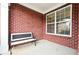 Charming brick porch featuring a comfortable bench, offering a cozy spot to relax and enjoy the outdoors at 1489 Belmont Hills Dr, Suwanee, GA 30024