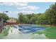 Well-maintained tennis court with green and blue surface surrounded by lush trees at 1489 Belmont Hills Dr, Suwanee, GA 30024