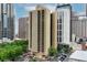 Tall tan building with trees at the base and buildings in the background at 300 Peachtree Ne St # 14H, Atlanta, GA 30308