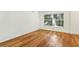 Comfortable bedroom featuring hardwood floors, a large window with blinds, and a neutral color scheme at 311 Peachtree Hills Ne Ave # 13B, Atlanta, GA 30305