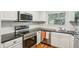 Modern kitchen features stainless steel appliances, white cabinets, and tiled backsplash at 311 Peachtree Hills Ne Ave # 13B, Atlanta, GA 30305