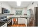 Well-lit kitchen with stainless steel appliances, white cabinets, and dark countertops at 311 Peachtree Hills Ne Ave # 13B, Atlanta, GA 30305