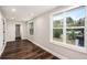 Bright bedroom featuring wood-look floors and multiple windows with views of mature trees at 6219 Heardsville Rd, Cumming, GA 30028
