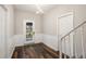 Elegant foyer featuring wood-look floors, wainscoting, and a modern light fixture for a grand entry at 6219 Heardsville Rd, Cumming, GA 30028