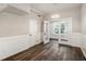 Well-lit room featuring wood-look floors, wainscoting, and glass doors for easy access to other areas at 6219 Heardsville Rd, Cumming, GA 30028
