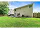 Large, lush backyard with green grass and mature trees features a patio area for relaxing or entertaining at 6561 Squire Pl, Douglasville, GA 30135