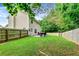 A fully fenced backyard featuring a patio area, lush lawn, and trees surrounds a two story home at 6561 Squire Pl, Douglasville, GA 30135