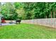 A fenced backyard with a patio, lawn and grill area is ideal for outdoor entertaining and relaxation at 6561 Squire Pl, Douglasville, GA 30135