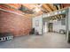 Open basement featuring exposed brick wall, concrete floor, open rafters and a ceiling fan at 3030 Winchester Dr, Cumming, GA 30041