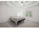 Bright bedroom with a tray ceiling, neutral carpet, and a window offering a view of the outside at 3030 Winchester Dr, Cumming, GA 30041