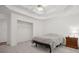 Bedroom featuring tray ceiling, carpeted floor, closet and a wooden nightstand with lamp next to bed at 3030 Winchester Dr, Cumming, GA 30041