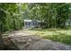 Quaint home with a front yard surrounded by mature trees providing shade and privacy at 3030 Winchester Dr, Cumming, GA 30041