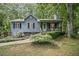 Charming one-story home with a cozy front porch, gray siding, black shutters, and lush landscaping at 3030 Winchester Dr, Cumming, GA 30041