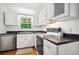 Cozy kitchen with white cabinets, stainless steel dishwasher and black countertop at 3030 Winchester Dr, Cumming, GA 30041