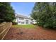 Expansive backyard with privacy fence, grassy area, and wooded backdrop offers a serene setting at 5156 Amberden Hall Dr, Suwanee, GA 30024