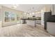 Bright kitchen with gray cabinets, granite countertops, a center island, and backyard views at 5156 Amberden Hall Dr, Suwanee, GA 30024