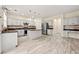 Bright eat-in kitchen featuring a large island, stainless steel appliances, and wood-look tile flooring at 5156 Amberden Hall Dr, Suwanee, GA 30024