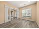 Bright living room featuring wood flooring, large window, and classic molding details at 5156 Amberden Hall Dr, Suwanee, GA 30024