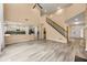 Open-concept living room leading into a modern kitchen with a staircase at 5156 Amberden Hall Dr, Suwanee, GA 30024