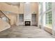 Bright living room featuring a fireplace, large windows, and hardwood staircase at 5156 Amberden Hall Dr, Suwanee, GA 30024