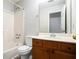 Bathroom featuring a shower-tub combo, wooden vanity, toilet, and a framed mirror at 6092 Giles Ct, Lithonia, GA 30058