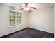 This carpeted bedroom is illuminated by a ceiling fan and natural light from a large window at 6092 Giles Ct, Lithonia, GA 30058