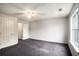 Spacious bedroom with carpeting, ceiling fan, large window, and convenient access to the bathroom at 6092 Giles Ct, Lithonia, GA 30058