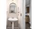Charming powder room featuring a pedestal sink and a decorative mirror and lighting at 6092 Giles Ct, Lithonia, GA 30058