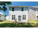 Back of a two-story home with vinyl siding and a small patio overlooking a nice lawn at 7268 Loblolly Ln, Morrow, GA 30260