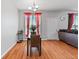 Bright dining area features hardwood floors, table, and window with red curtains at 7268 Loblolly Ln, Morrow, GA 30260