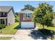 Two-story home with a brick and stone facade, two car garage and a well manicured lawn and mature tree in the front yard at 7268 Loblolly Ln, Morrow, GA 30260