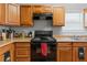 Close-up of the kitchen featuring wooden cabinets, stove, and stainless steel sink at 7268 Loblolly Ln, Morrow, GA 30260
