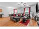 Cozy living room with a large sectional sofa, wood floors, and a view of the dining area at 7268 Loblolly Ln, Morrow, GA 30260
