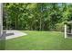A spacious backyard with a concrete patio and lush green lawn at 8592 Hidden Creek Cir, Snellville, GA 30039