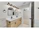 Bathroom with double sinks, modern lighting, and doorway view to an en-suite bedroom at 8592 Hidden Creek Cir, Snellville, GA 30039
