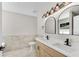 Bathroom featuring double sinks, wood cabinets, modern lighting, and decorative mirrors at 8592 Hidden Creek Cir, Snellville, GA 30039