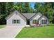 Charming single-story home featuring a well-manicured lawn, blue shutters, and a welcoming entrance at 8592 Hidden Creek Cir, Snellville, GA 30039