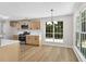 Modern kitchen with stainless steel appliances, light cabinets, and a dining area with natural light at 8592 Hidden Creek Cir, Snellville, GA 30039